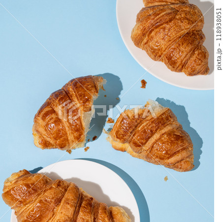 Flat lay of  fresh croissants on blue background with shadow.  Flat lay of  fresh croissants on blue background with shadow.  118938051