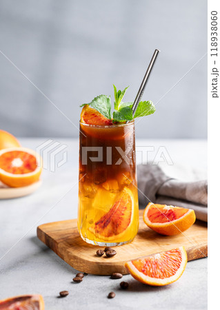 Coffee with orange juice (bumble) in a tall glass with ice and mint on a wooden board  118938060