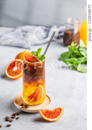 Espresso coffee with orange juice (bumble) in a tall glass with ice and mint on a blue background Espresso coffee with orange juice (bumble) in a tall glass with ice and mint on a blue background 118938672