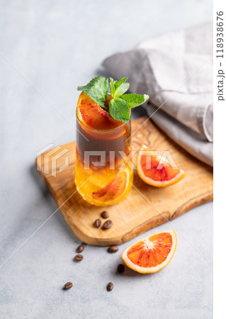 Coffee with orange juice (bumble) in a tall glass with ice and mint on a wooden board  118938676