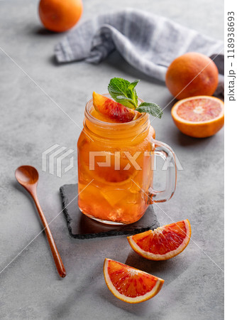 Freshly squeezed blood orange juice with ice, mint and a slice of fruit in a jar on blue background 118938693