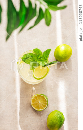Lime mojito in a glass with mint and ice. Refreshing citrus cocktail with lime on a light background Lime mojito in a glass with mint and ice. Refreshing citrus cocktail with lime on a light background 118938748
