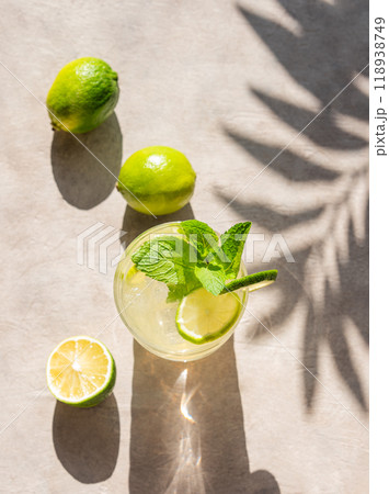 Lime mojito in a glass with mint and ice. Refreshing citrus cocktail on a light background  118938749