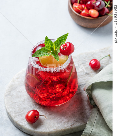 Cherry-lime mojito cocktail with mint, lime and ice on a marble  board on a light background  118938982