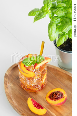 Peach refreshing drink with ice and mint on a wooden board on a white table. Fresh homemade lemonade Peach refreshing drink with ice and mint on a wooden board on a white table. Fresh homemade lemonade 118939004