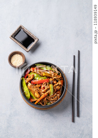Stir-fry with soba noodles, meat and vegetables on a light background. Stir-fry with soba noodles, meat and vegetables on a light background. 118939149