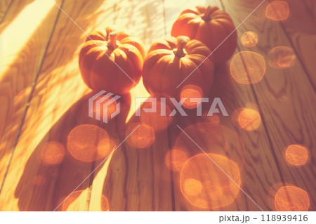 Halloween scene bright orange pumpkins on wooden table with glowing bokeh background 118939416