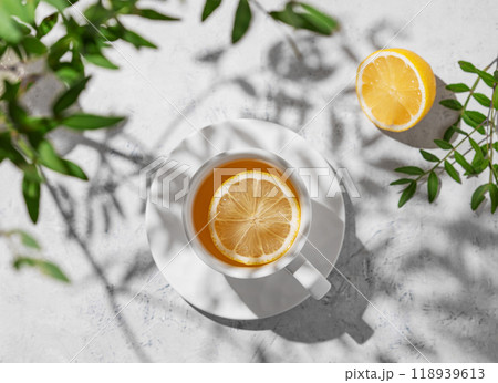 A cup of tea with lemon and green branch on a white table.  Breakfast detox and healthy concept. 118939613