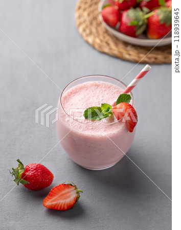 A glass of fresh strawberry smoothie with mint on a blue background with fresh berries. A glass of fresh strawberry smoothie with mint on a blue background with fresh berries. 118939645