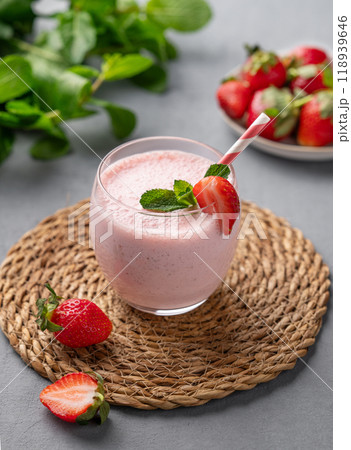 A glass of fresh strawberry smoothie with mint on a blue background with fresh berries. A glass of fresh strawberry smoothie with mint on a blue background with fresh berries. 118939646