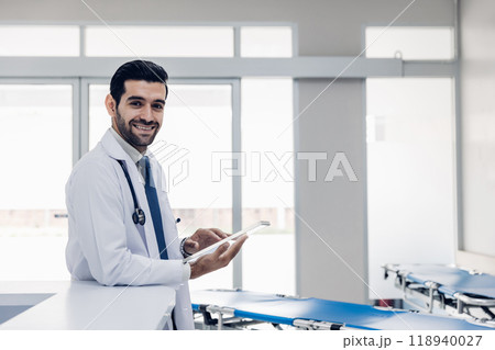doctor in white coat Standing using cellphone applications in clinic office. Man with healthcare, medical and wellness app on mobile technology or search internet 118940027