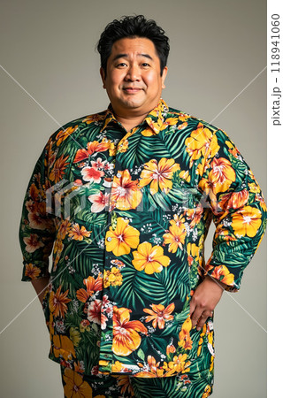 A man in a green and yellow floral shirt poses for a picture 118941060