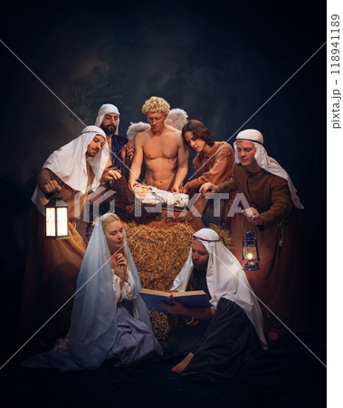 Christmas Nativity scene with Mary, Joseph, baby Jesus, shepherds and angels praying, reading Bible. Biblical moment of Jesus Christ birth 118941189