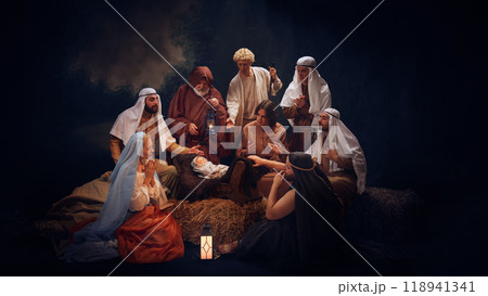 The Holy Family and wise men gather in prayer around baby Jesus. Hope and the light of salvation on Christmas night. The Holy Family and wise men gather in prayer around baby Jesus. Hope and the light of salvation on Christmas night. 118941341