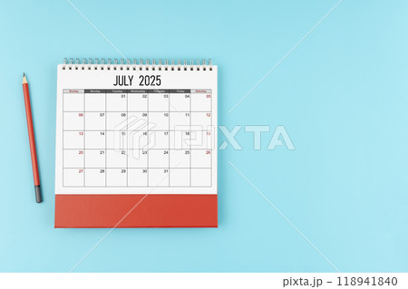 July desk calendar for 2025 year with pencil on blue background, Position with copy space. July desk calendar for 2025 year with pencil on blue background, Position with copy space. 118941840