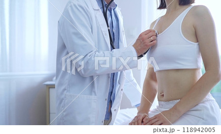 Doctor and patient. Physician is using stethoscope examining woman lungs in clinic cabinet. Medicine and health care 118942005