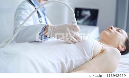 Doctor man using ultrasound equipment on the breast of a female patient. Female breast cancer prevention. mammary gland health. Medicine concept Doctor man using ultrasound equipment on the breast of a female patient. Female breast cancer prevention. mammary gland health. Medicine concept 118942439