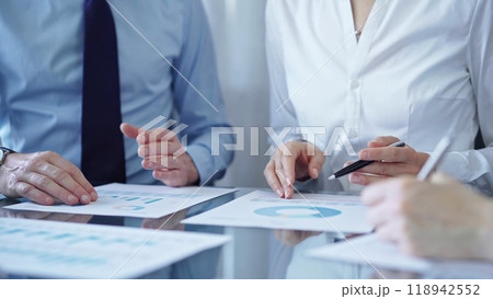 Business people are reviewing a financial results and discussing the terms of the agreement. Teamwork and planning Business people are reviewing a financial results and discussing the terms of the agreement. Teamwork and planning 118942552