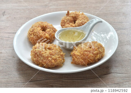 crispy fried mashed shrimp cake coating flake bread and flour on plate dipping with sweet plum sauce 118942592