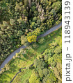 Aerial View of a Serene and Winding Road That Winds Through a Lovely Lush Green Forest Area 118943139