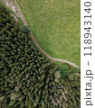 A Stunning Aerial View of a Lush Forest Surrounded by a Scenic Green Meadow Pathway 118943140