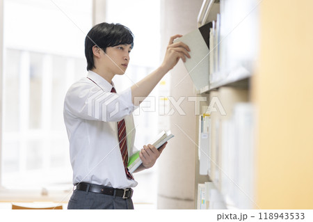 図書室で本を選ぶ男子高校生 118943533