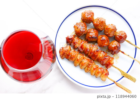 炭火でじっくり焼き上げたおいしそうな焼き鳥(つくね串と、ぼんじり)と、赤ワインのグラス 炭火でじっくり焼き上げたおいしそうな焼き鳥(つくね串と、ぼんじり)と、赤ワインのグラス 118944060