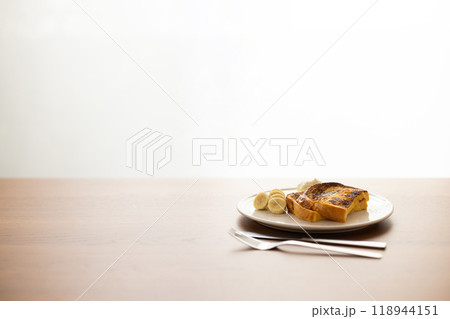朝日の差し込む窓辺で、木製のテーブルの上に置かれたフレンチトースト 朝日の差し込む窓辺で、木製のテーブルの上に置かれたフレンチトースト 118944151