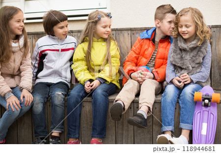 Children on a bench playing Chinese whispers Children on a bench playing Chinese whispers 118944681