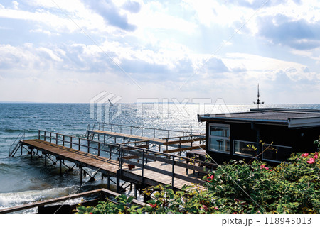 Beautiful seascape with sailing boat in the distance and pier 118945013