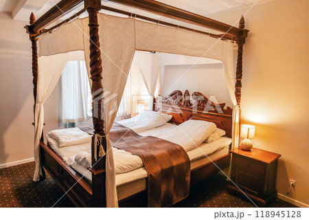 Wooden four-poster bed in a hotel room. 118945128