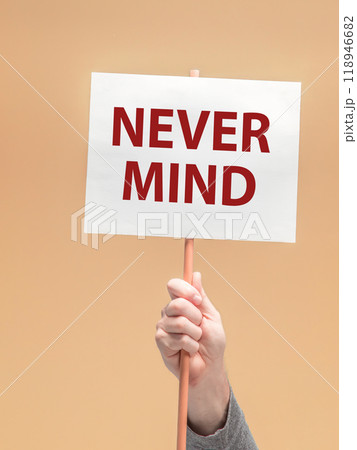 Male hand holding sign with the phrase NEVER MIND Male hand holding sign with the phrase NEVER MIND 118946682