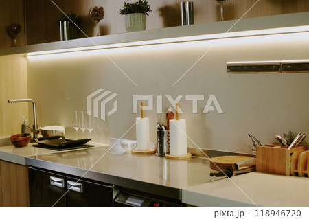 Wooden kitchen counter with kitchenware and dishes on white granite top Wooden kitchen counter with kitchenware and dishes on white granite top 118946720