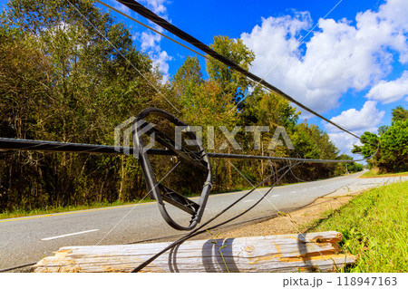 Storm damaged power lines lie broken on ground following hurricane Storm damaged power lines lie broken on ground following hurricane 118947163