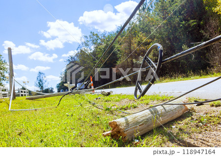 In aftermath of hurricane, damaged power lines lie on ground with broken wires attached In aftermath of hurricane, damaged power lines lie on ground with broken wires attached 118947164