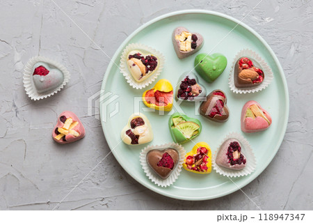 Plate with different chocolate on colored background. Assortment of fine chocolates top view vith copy space Health and obesity concept Plate with different chocolate on colored background. Assortment of fine chocolates top view vith copy space Health and obesity concept 118947347