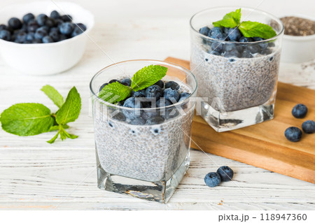 Healthy breakfast or morning with chia seeds vanilla pudding and blueberry berries on table background, vegetarian food, diet and health concept. Chia pudding with coconut milk and blueberry Healthy breakfast or morning with chia seeds vanilla pudding and blueberry berries on table background, vegetarian food, diet and health concept. Chia pudding with coconut milk and blueberry 118947360