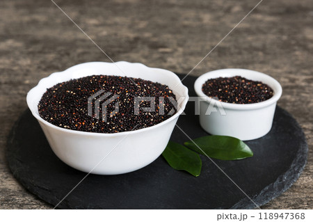 quinoa seeds in bowl on colored background. Healthy kinwa in small bowl. Healthy superfood quinoa seeds in bowl on colored background. Healthy kinwa in small bowl. Healthy superfood 118947368