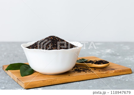 quinoa seeds in bowl and spoon on colored background. Healthy kinwa in small bowl. Healthy superfood quinoa seeds in bowl and spoon on colored background. Healthy kinwa in small bowl. Healthy superfood 118947679