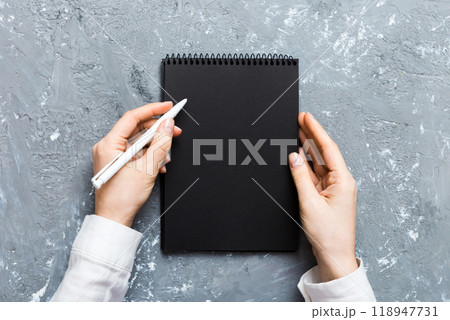 Woman hand with pencil writing on notebook. Woman working on office table. Female hand holding pencil and sketchbook. Mock-up Concept Woman hand with pencil writing on notebook. Woman working on office table. Female hand holding pencil and sketchbook. Mock-up Concept 118947731