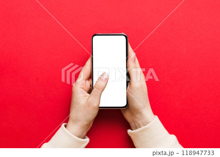 Top view of woman hands holding smart phone with blank copy space screen for your text message or information content. woman hand using phone white screen on top view 118947733