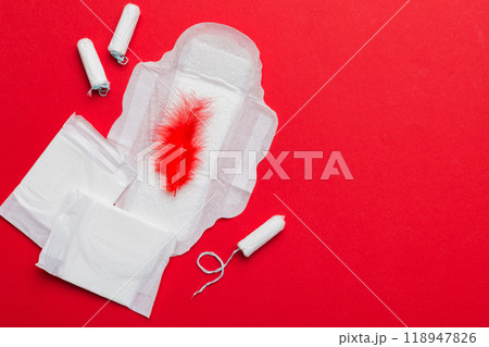women pads and tampon - sanitary pads lies next to a tampon on an isolated background on a pink and violet background. Women's hygiene and menstrual period concept women pads and tampon - sanitary pads lies next to a tampon on an isolated background on a pink and violet background. Women's hygiene and menstrual period concept 118947826