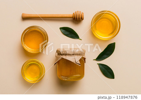 Honey jar with wooden honey dipper on white background top view with copy space. Delicious honey bottle 118947876