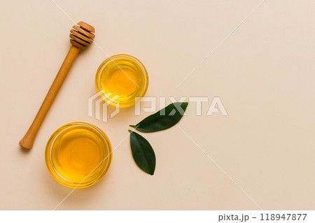 Honey jar with wooden honey dipper on white background top view with copy space. Delicious honey bottle 118947877