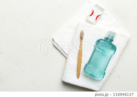Mouthwash and other oral hygiene products on colored table top view with copy space. Flat lay. Dental hygiene. Oral care products and space for text on light background. concept Mouthwash and other oral hygiene products on colored table top view with copy space. Flat lay. Dental hygiene. Oral care products and space for text on light background. concept 118948137