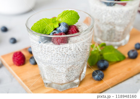 Healthy breakfast or morning with chia seeds vanilla pudding raspberry and blueberry berries on table background, vegetarian food, diet and health concept. Chia pudding with raspberry and blueberry 118948160