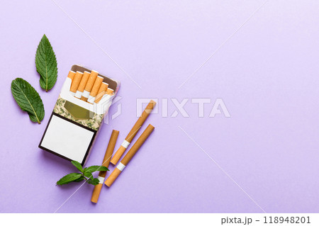 Pack of menthol cigarettes and fresh mint on colored table, Menthol cigarettes top view flat lay Pack of menthol cigarettes and fresh mint on colored table, Menthol cigarettes top view flat lay 118948201