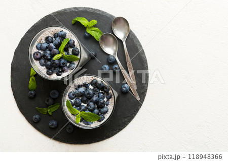 Healthy breakfast or morning with chia seeds vanilla pudding and blueberry berries on table background, vegetarian food, diet and health concept. Chia pudding with coconut milk and blueberry 118948366