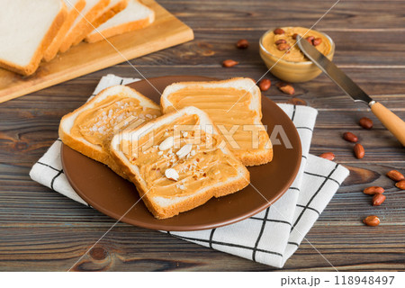 Peanut butter sandwiches or toasts on light table background.Breakfast. Vegetarian food. American cuisine top view vith copy space 118948497