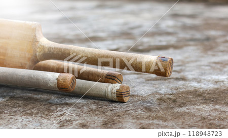 Wooden cricket bat handles resting on a dark surface, symbolizing the concept of physical activity through cricket and the passion of cricket enthusiasts, the sport's role in fitness and recreation. 118948723